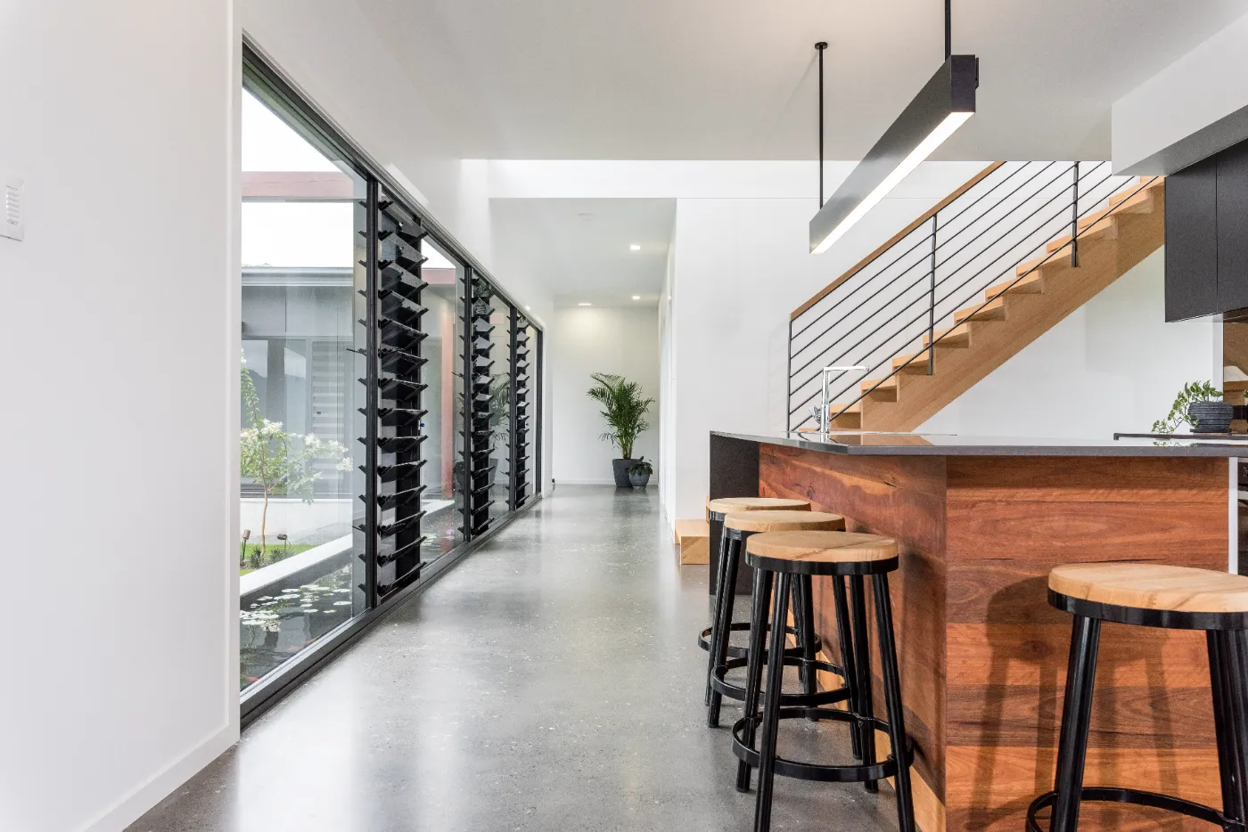 Mechanically polished concrete floor with minimum stone exposure and a semi gloss finish in a Brisbane home with a koi pond