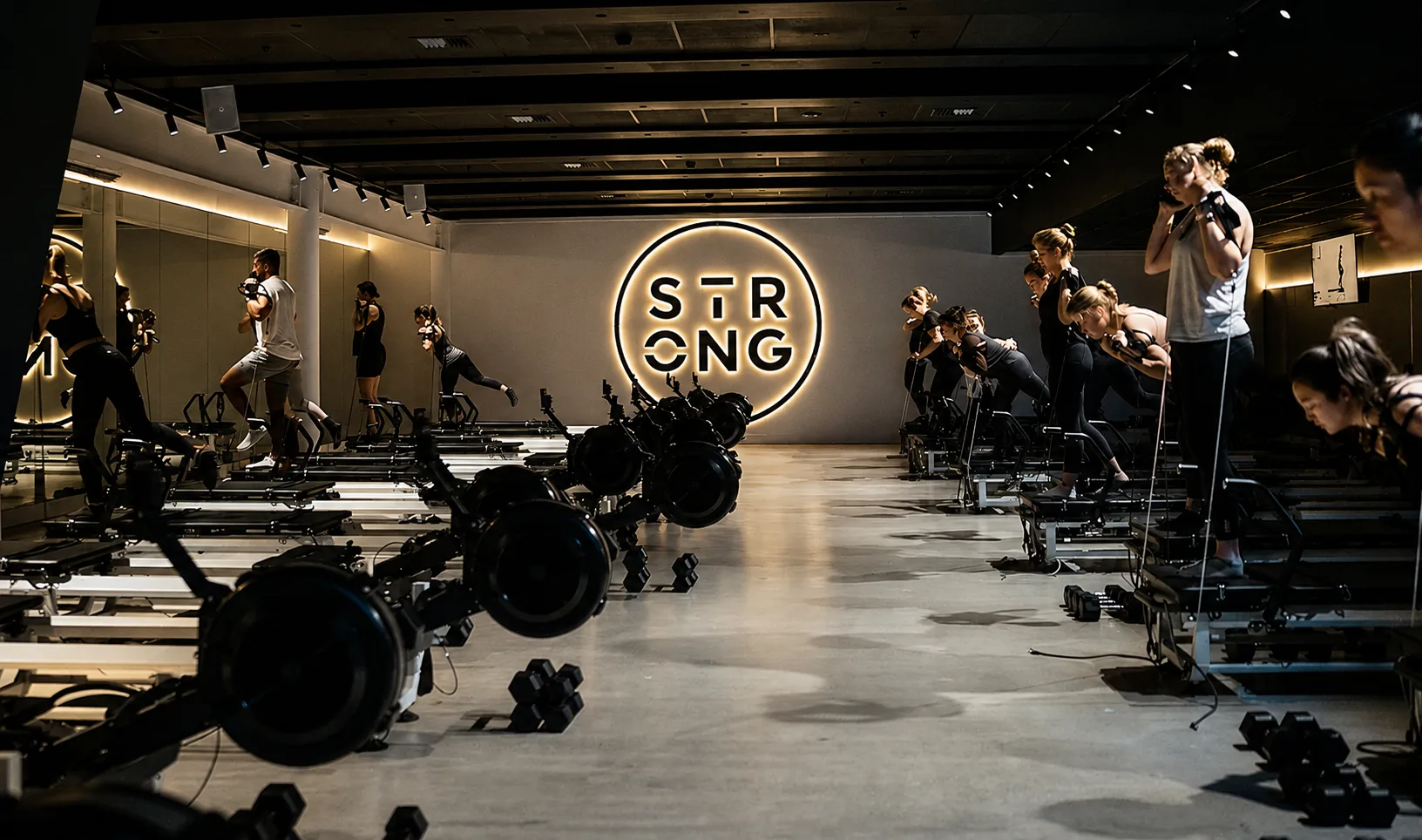 Mechanically polished concrete floor in a Brisbane fitness studio filled with reformer machines