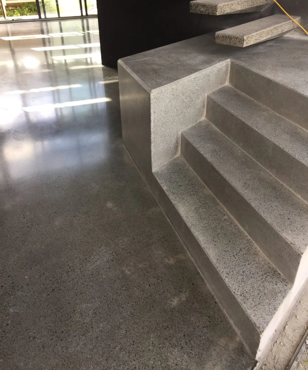Polished concrete staircase with full stone exposure in a Brisbane home